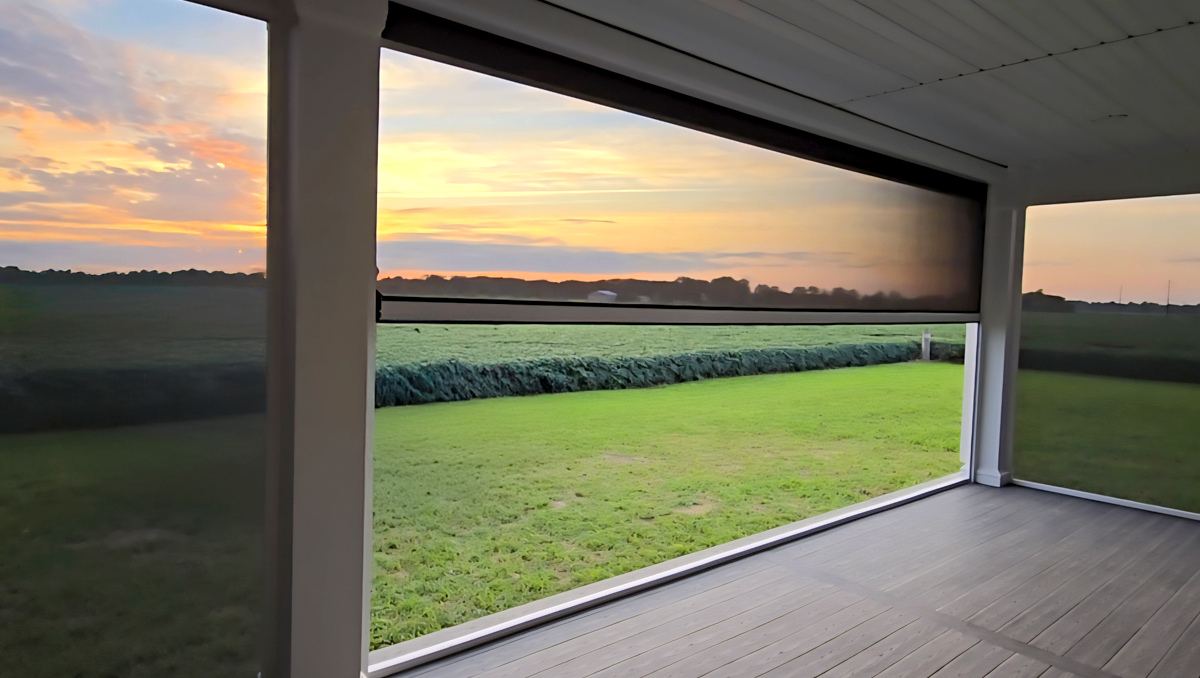 Motorized shade screens partially lowered on a covered porch at sunset in Galena Maryland, providing glare control and comfortable outdoor living on the Eastern Shore.