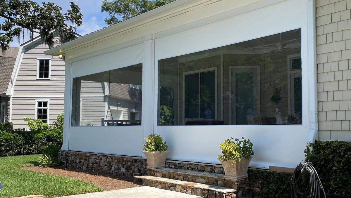 motorized porch screen system installed on covered outdoor living space with white framing