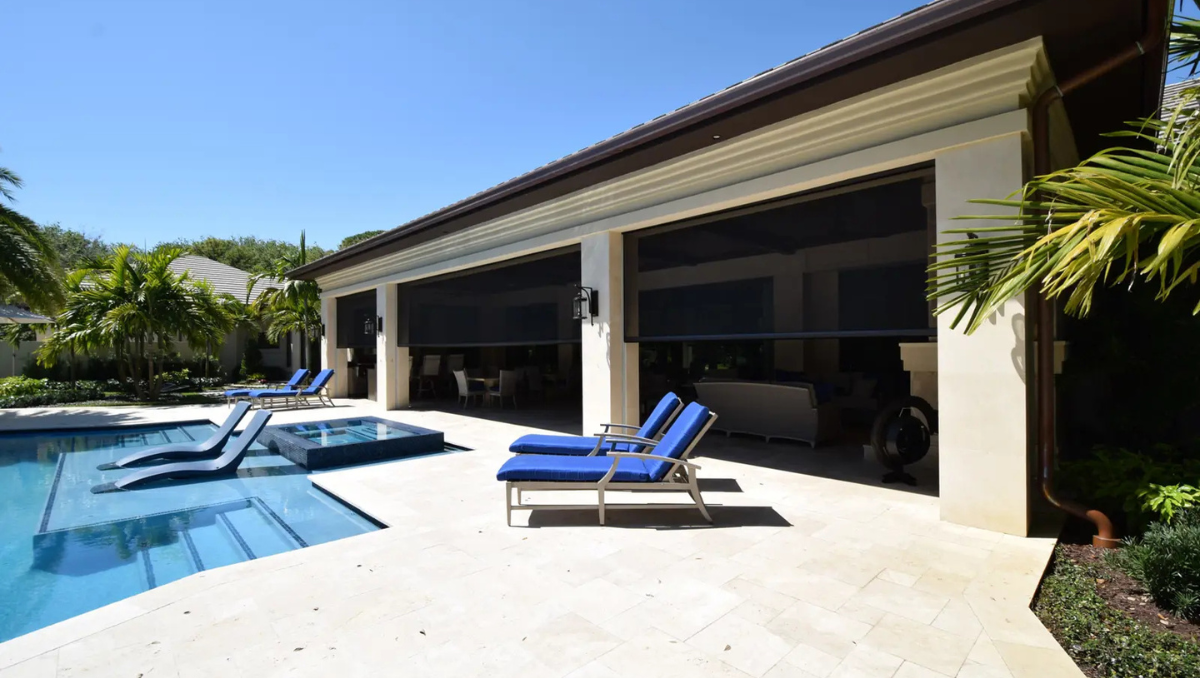 outdoor living area with shade screens providing sun protection near pool