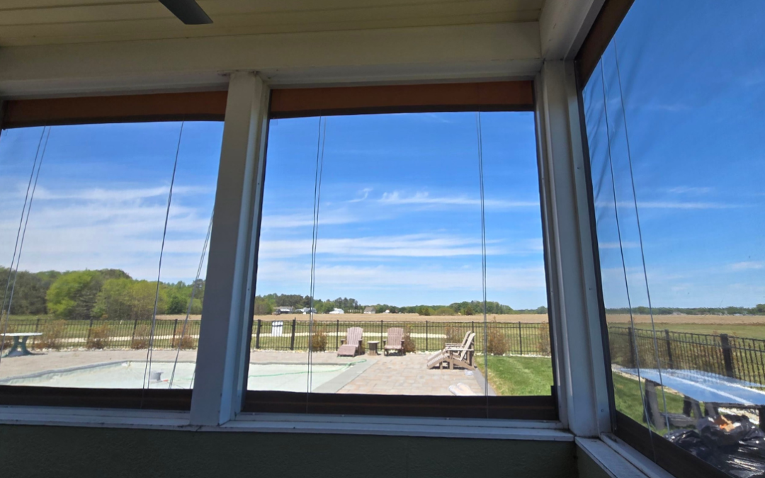 Interior view of manual vinyl porch enclosures installed on a screened porch in Milton Delaware with clear countryside views