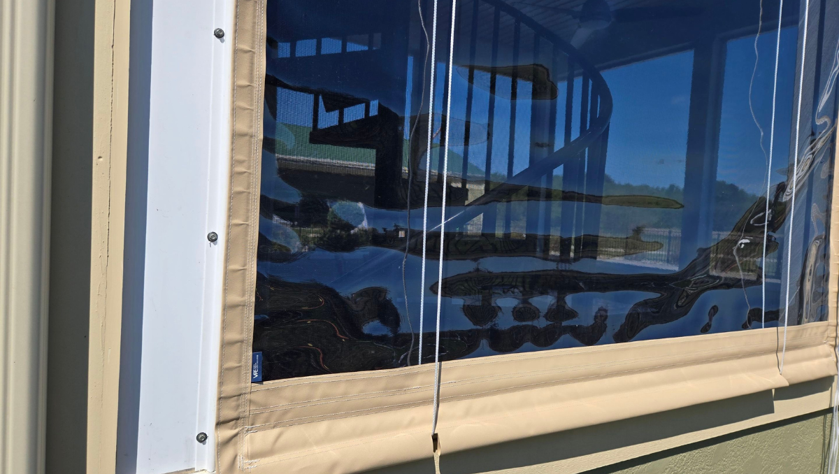 Close-up detail of beige manual vinyl porch enclosure color matched to home siding in Delaware