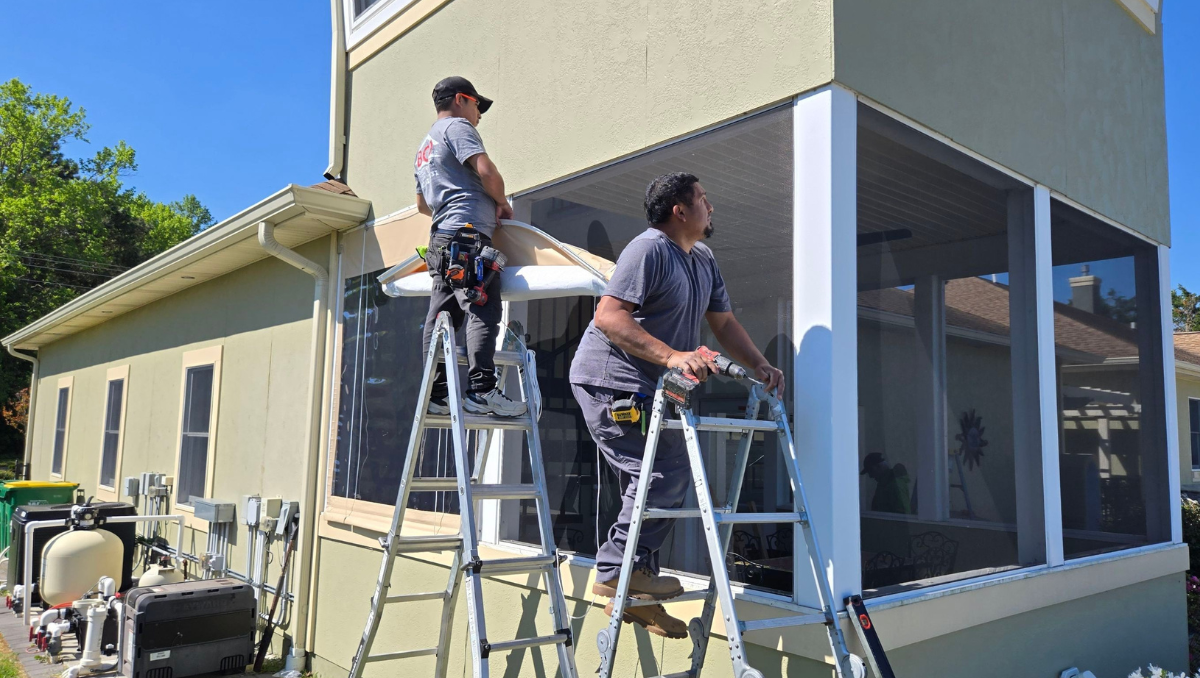 BCO Construction installers fitting manual vinyl porch enclosures on a home in Milton Delaware