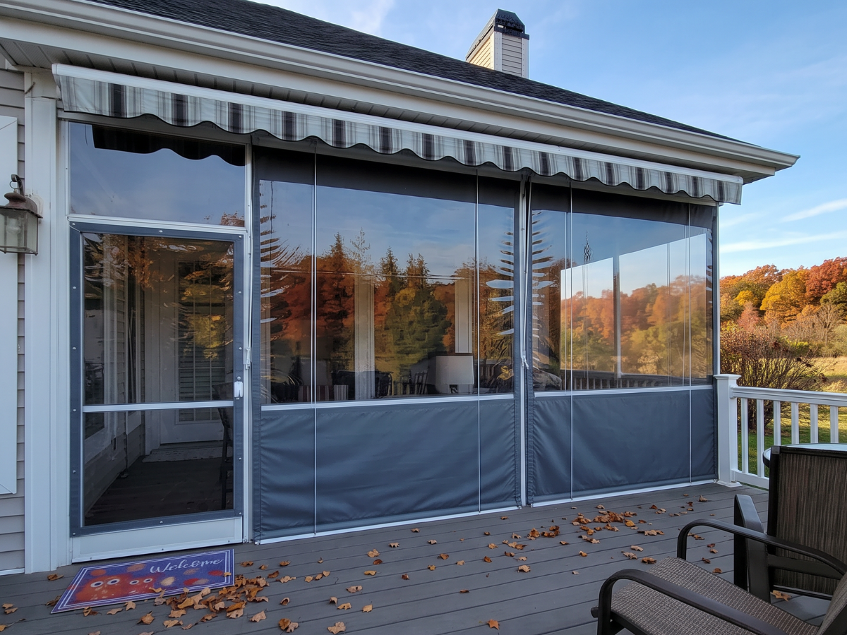 Exterior view of a porch protected with clear vinyl panels overlooking colorful autumn foliage.