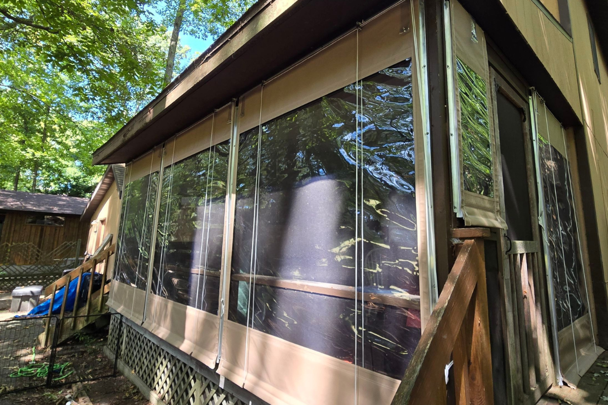 Clear roll-down panels installed around an existing screened porch